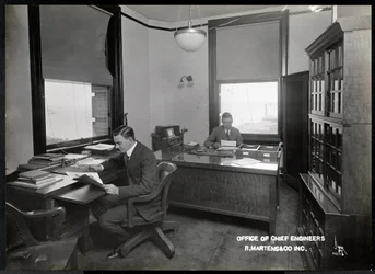 Två män på kontoret för chefsingenjörerna vid R. Martens und Co. Inc., New York, 1916 eller 1917 (silvergelatintryck)